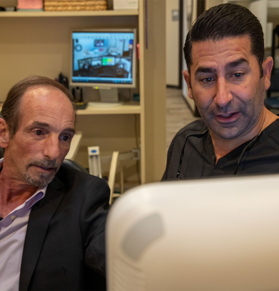 patient and doctor going over dental treatment information within the dentistry